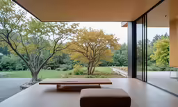 the room has large open windows that look out onto trees