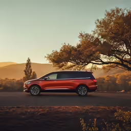 the front end of a red suv on a road