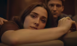 a couple looks to their left as they lie in bed