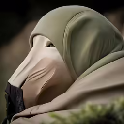 a person wearing a mask is sitting outside