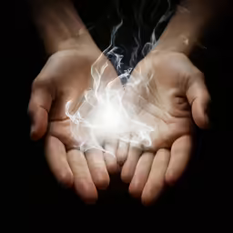 two hands holding a glowing object with lights coming from the top