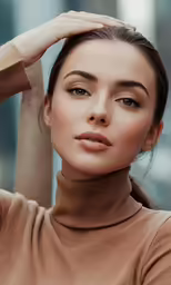 a woman in brown poses with her hands behind her head