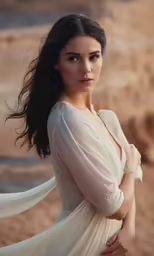 the girl is posing on the beach with her dress flowing