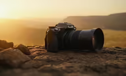 a camera sitting on a hill with a beautiful sun setting behind it