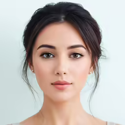 a beautiful young woman posing in front of a white wall