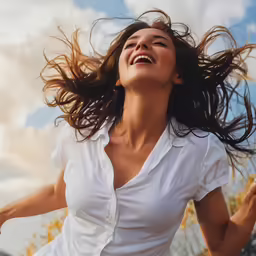 a woman with wind in her hair smiling and posing for the camera
