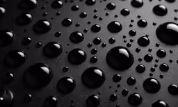 many black water droplets on a black surface