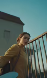 a woman with a bag and frisbee by a fence