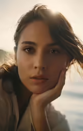 a woman sitting on the shore by the ocean