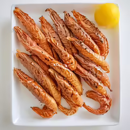 an assortment of fish sticks sit on a plate next to a lemon