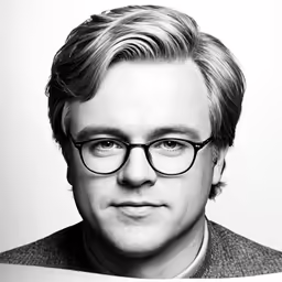 a man with glasses looking at the camera