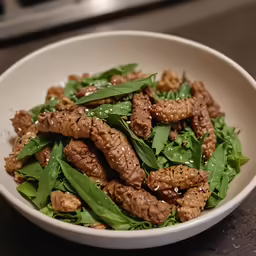 a white bowl filled with meat and vegetables