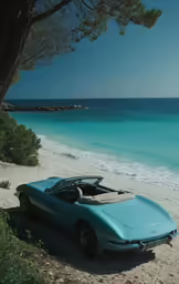 a blue car parked on the beach by the ocean