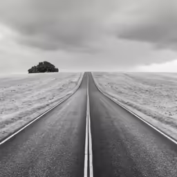 a long road leading into the horizon on a gloomy day