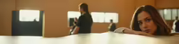 there is a woman sitting and a man standing in the background