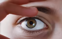 an eye and hand are touching something over their eyes