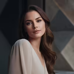 a woman standing in a room with a long white dress on