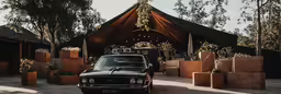 a vintage car is parked on a brick patio