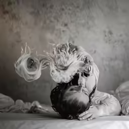 a woman laying on top of a bed covered in blankets