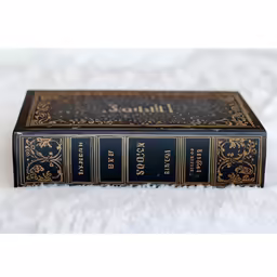 a small blue book sitting on top of a bed