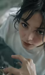 a woman is pointing and staring directly at the camera