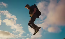 a man jumping up into the air with his backpack