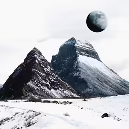 the mountain tops are covered with snow with a crescention moon