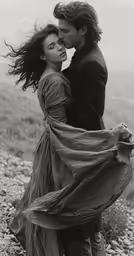 a man and woman kissing while standing in the grass