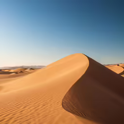 sand dunes in the desert against a blue sky