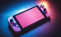 an orange and white nintendo wii game controller with red screen