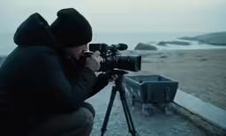 a man is taking pictures on the beach