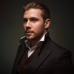 a man posing with dark background in suit