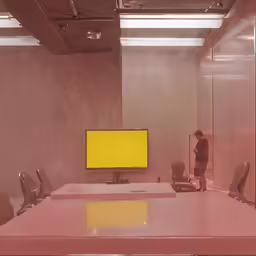 a meeting room with large mirror wall and yellow screen