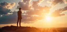 a man standing on top of a mountain at sundown