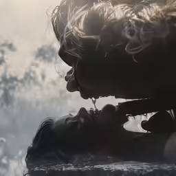 a woman and a man kiss and have smoke all around them