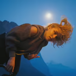 a woman with blond hair is flying through the air