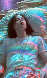 the girl is sleeping on her side in bed under a blanket with colorful lights