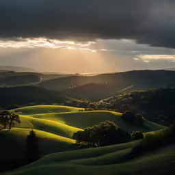 the sun breaking through some dark clouds over rolling hills