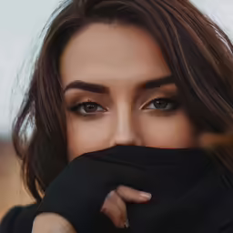 a girl covers her face with one hand and stares straight ahead
