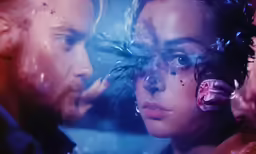 a couple is looking into a mirror at each other
