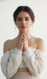 a woman wearing a white blouse with a pearled collar