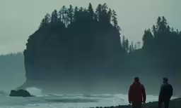 two men standing near the water at a beach