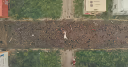 an aerial view of a dirt road and grass