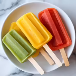 three different colored popsicles with pops on them
