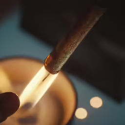 a cigarette with a lit tip coming from a burner