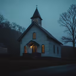 a white church in the fog with trees around