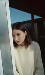 a woman standing in front of glass doors