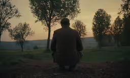 an old man is looking out into the woods