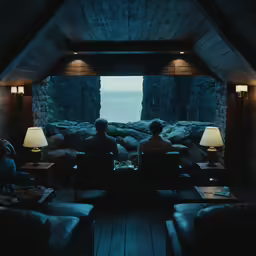 two people sit on leather couches in front of a rocky window
