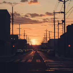 a street with cars going through it and the sun setting in the distance